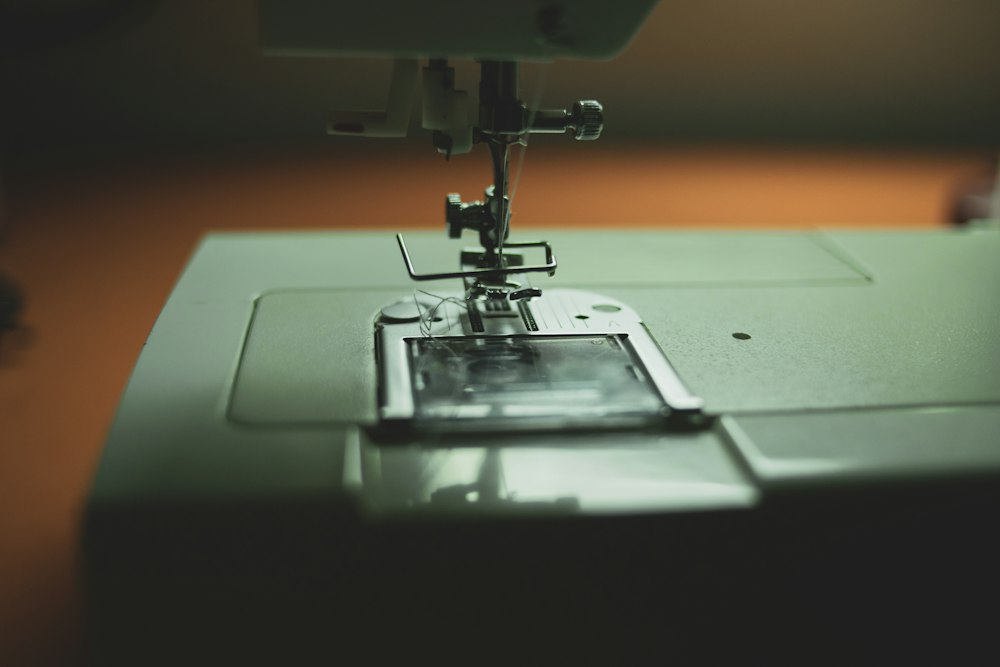 Close-up view of the needle and presser foot on a white sewing machine